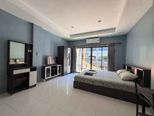 Furnished guest room with balcony door